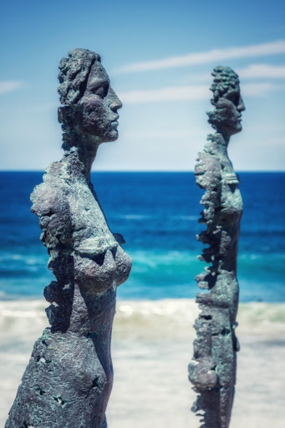 Gray concrete statue near body of water during daytime