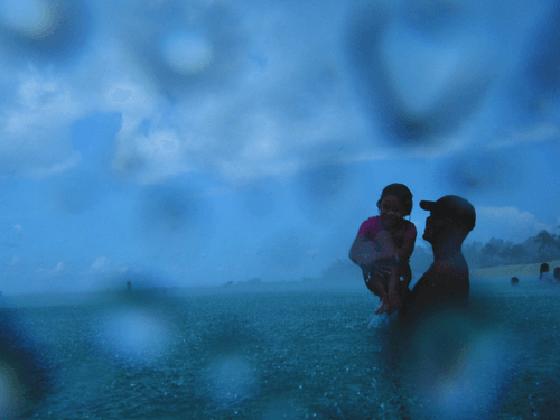 Father and Daughter in the Water in the Rain